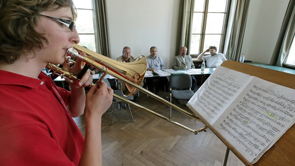 Ein junger Posaunist musiziert während seiner Aufnahmeprüfung an der Musikhochschule in München vor der Prüfungskommission.  | Bild: picture-alliance/ dpa | Peter Kneffel