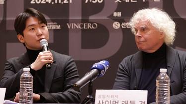 Der Pianist Seong-Jin Cho und Dirigent Sir Simon Rattle bei einer Pk während der Asien-Tournee des BRSO. | Bild: picture alliance / YONHAPNEWS AGENCY | Yonhap