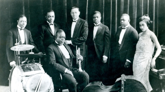 Joe 'King Oliver und seine Jazz-Band / Foto 1923 Oliver, Joe 'King' US-amerikan. Kornettist (New Orleans Jazz-Musiker); 11.5.1885 New Orleans (Louisiana) - 10.4.1938 Savannah (Georgia). - Joe 'King' Oliver (Mitte) mit seiner 1922 gegründeten 'King's Oliver's Creole Jazz Band' (v.l., 'Baby' Dodds, Horace Dubrey, Bill Johnson, Louis Armstrong, Johnny Dodds und Lillian Hardin Armstrong) | Bildquelle: picture alliance / akg-images | akg-images