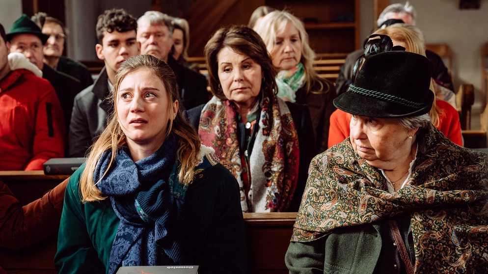 Dahoam is Dahoam: Sarah (Sophie Reiml, links) ist von der Botschaft der Auferstehung im Ostergottesdienst überfordert. Mit Rosi (Brigitte Walbrun, Mitte), Margot (Sarah Camp, rechts) und Komparserie. | Bildquelle: BR/Nadya Jakobs