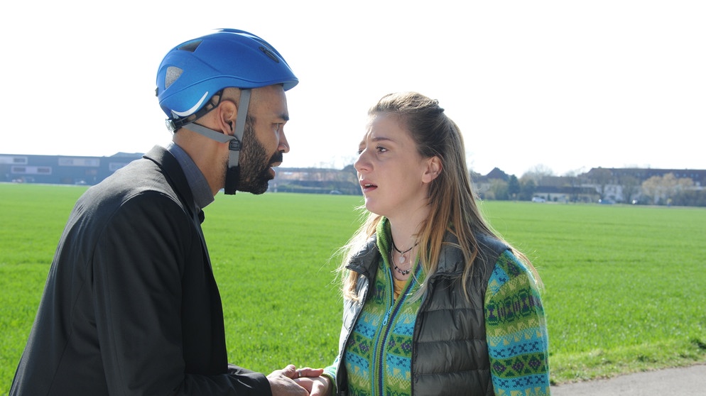 Dahoam is Dahoam: Als Sarah (Sophie Reiml) Zeugin eines harmlosen Fahrradunfalls von Pfarrer Naveen (Markus Subramaniam) wird, holt ihr Trauma sie mit voller Wucht ein. | Bildquelle: BR/Marco Orlando Pichler