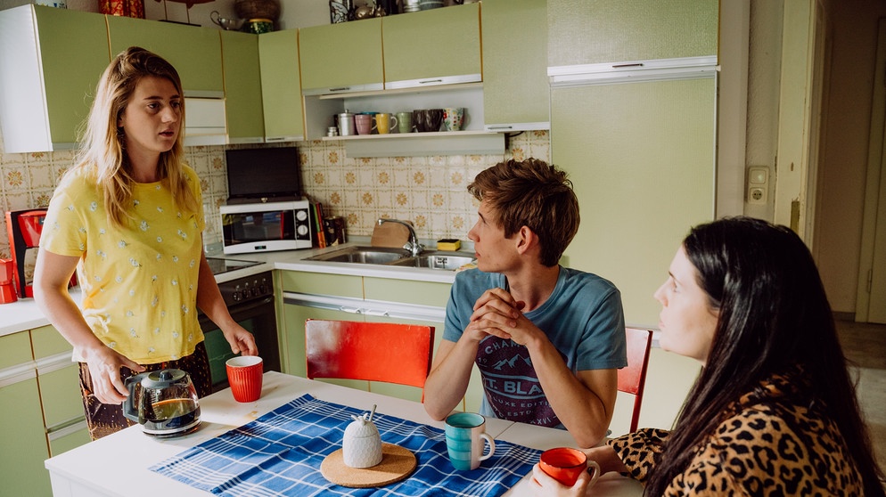 Dahoam is Dahoam: Sarah (Sophie Reiml, links) ist sich sicher, ihre tote Frau Jenny gesehen zu haben. Mit Joschi (Adrian Bräunig) und Tina (Anita Eichhorn, rechts). | Bildquelle: BR/Nadya Jakobs