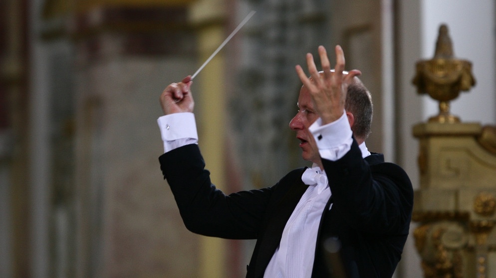 Dass der "Operettenkönig" Franz von Suppé auch Komponist geistlicher Musik war, ist weitgehend unbekannt. Umso bedeutender war die Wiederaufführung seines Requiems in d-Moll für Soli, Chor und Orchester beim Klangfest Ebrach 2012. Die Philharmonie Festiva und der Philharmonische Chor München unter der Leitung von Gerd Schaller (im Bild) überzeugen mit einer bewegenden Interpretation des 1855 entstandenen Werks, in dem Franz von Suppé zu einer ganz eigenen romantischen Klangsprache findet. | Bildquelle: BR/Ebracher Musiksommer