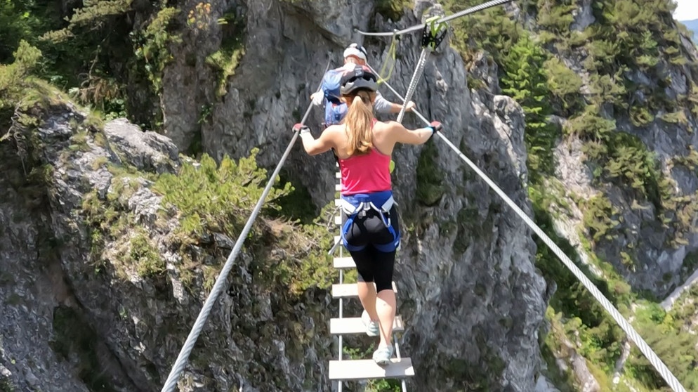 War das Gebirge einst ein Abenteuer, die Gipfel erreichbar nur für die zähen Wanderer und Kletterer, ist es nun zum Freizeitpark für jedermann geworden. Denn allein der Sommertourismus beschert den Alpenländern über 12,5 Milliarden Euro Umsatz alljährlich. Gibt es Alternativen zu diesem jeden Winkel beanspruchenden Alpenboom? Im Bild: Gesicherter Nervenkitzel – Klettersteig am Dachstein. | Bildquelle: WDR