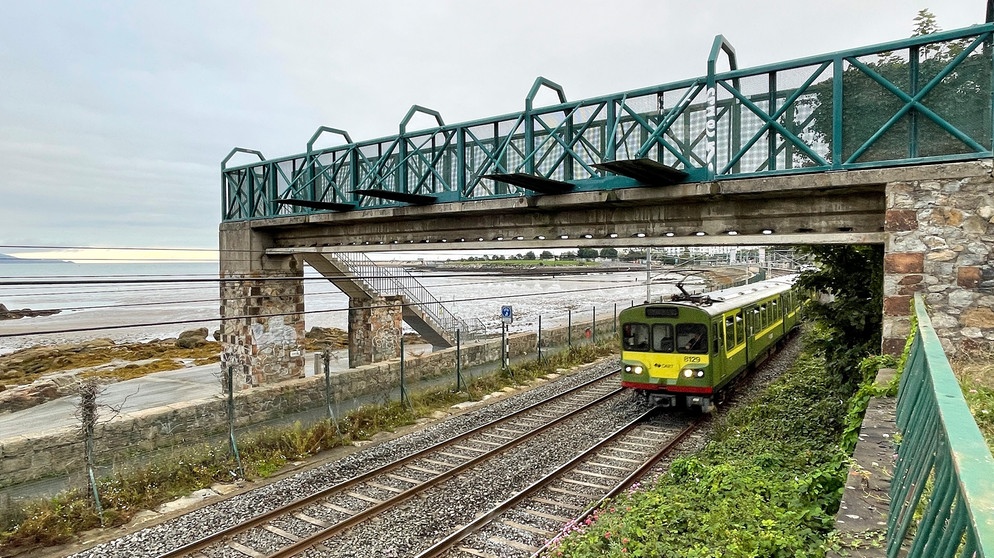 Der irische Nahverkehrszug DART fährt dicht an der Dublin-Bay entlang. Bei Ebbe zeigt sie sich als riesige Watt-Landschaft. | Bildquelle: SWR/Kirsten Ruppel