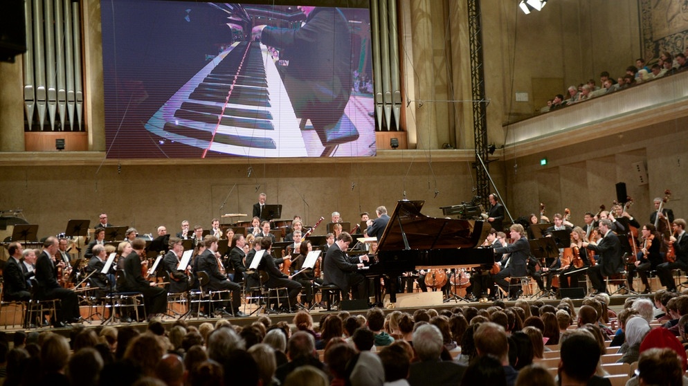 Projekt und Konzert mit dem Symphonieorchester des Bayerischen Rundfunks unter der Leitung von Mariss Jansons. Als Gast: Pianist Denis Matsuev. Durch das Programm führen die BAYERN 3-Frühaufdreher Claudia Conrath, Axel Robert Müller und Bernhard Fleischmann. | Bildquelle: Honorarfrei lediglich für Ankündigungen und Veröffentlichungen im Zusammenhang mit obiger BR-Sendung bei Nennung: Bild: BR/Annette Goossens. Die Nutzung im Social Media-Bereich sowie inhaltlich andere Verwendungen nur nach vorheriger schriftlicher Vereinbarung mit dem BR-Bildmanagement, Tel. 089 / 5900 10580, Fax 089 / 5900 10585, Mail Bildmanagement@br.de