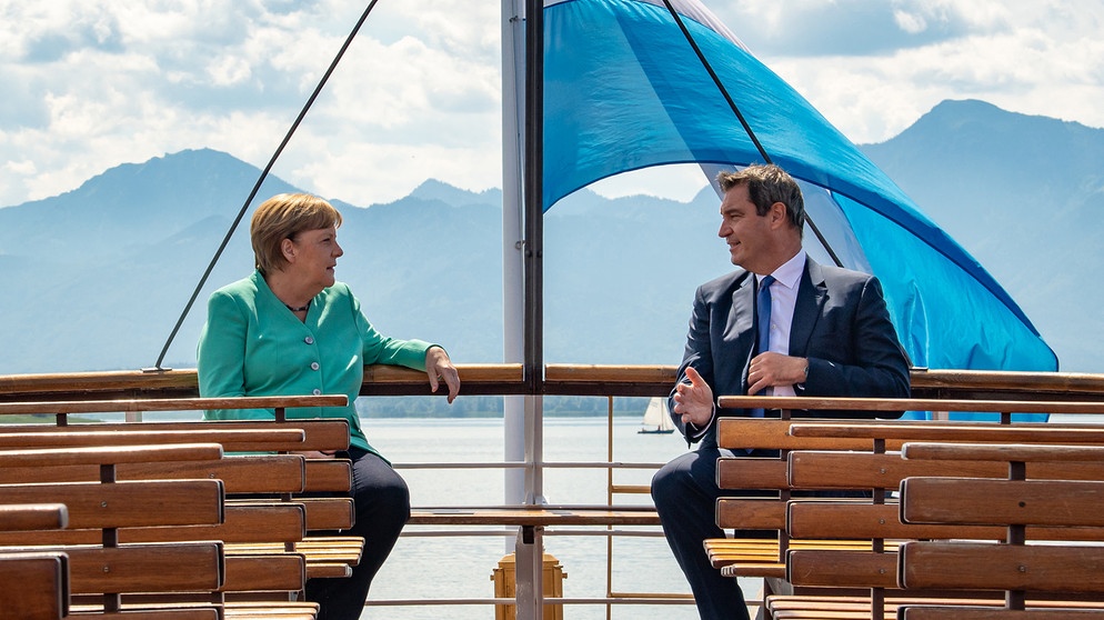 14.07.2020, Bayern, Prien Am Chiemsee: Markus Söder (CSU), Ministerpräsident von Bayern, und Bundeskanzlerin Angela Merkel (CDU), fahren gemeinsam mit einem Schiff der Chiemsee-Schifffahrt auf die Insel Herrenchiemsee. Dort findet die bayerische Kabinettssitzung in der Spiegelgalerie des Neuen Schlosses statt, an der Merkel teilnimmt. Foto: Peter Kneffel/dpa/Pool/dpa +++ dpa-Bildfunk +++ | Bildquelle: dpa-Bildfunk/Peter Kneffel